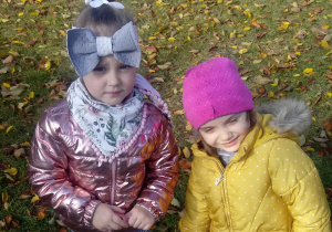 Dziewczynki spacerują wśród jesiennych liści